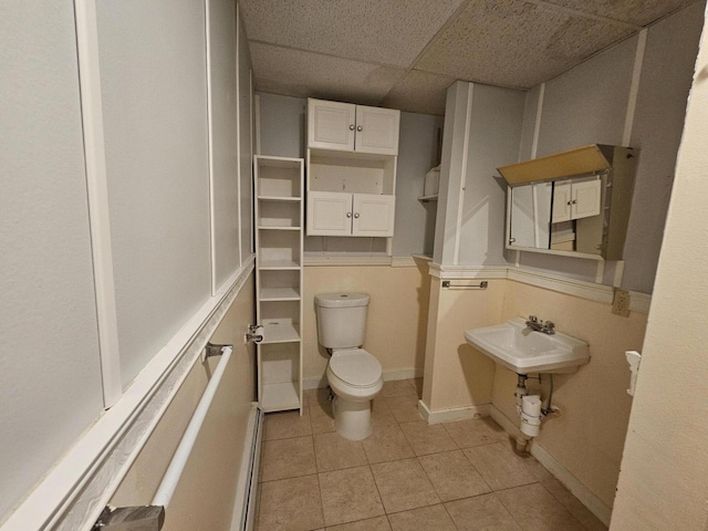 55 Cony St, Augusta, ME 04330 - half bathroom featuring toilet, tile patterned floors, a drop ceiling, a baseboard radiator, and baseboards