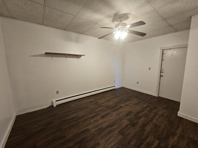 55 Cony St, Augusta, ME 04330 - empty room with a baseboard radiator, a drop ceiling, a ceiling fan, dark wood-style flooring, and baseboards