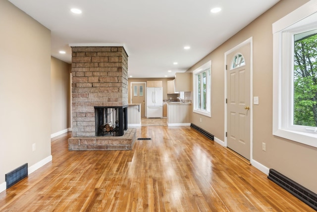 7 Alweber Rd, Windham, ME 04062 - unfurnished living room featuring light wood-style flooring, recessed lighting, baseboards, a brick fireplace, and a baseboard radiator
