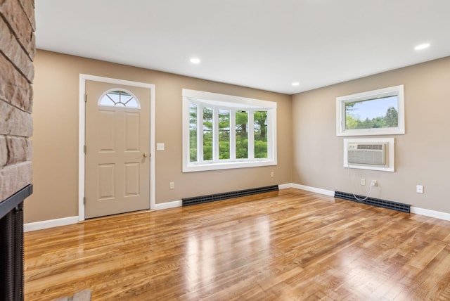 7 Alweber Rd, Windham, ME 04062 - entrance foyer with baseboard heating, a wall mounted AC, light wood-type flooring, baseboards, and a large fireplace