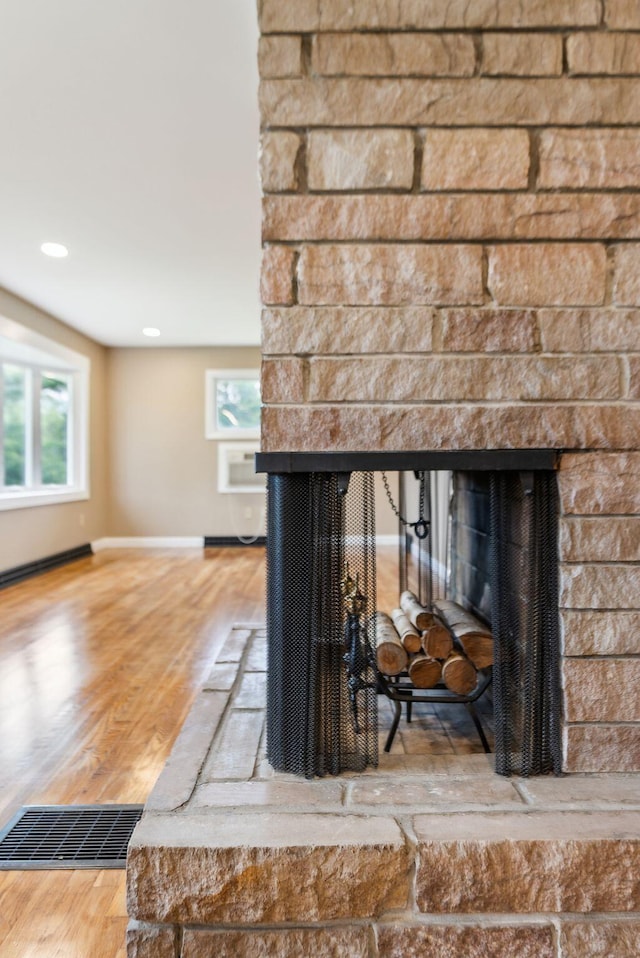 7 Alweber Rd, Windham, ME 04062 - detailed view of a multi sided fireplace, wood finished floors, baseboards, baseboard heating, and recessed lighting