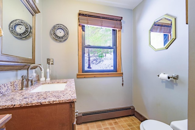 bathroom featuring toilet, vanity, baseboards, baseboard heating, and tile patterned floors