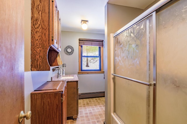 bathroom with a shower with shower door, a baseboard radiator, and vanity