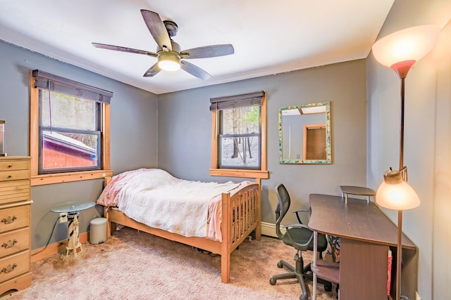 bedroom featuring a ceiling fan, light colored carpet, and baseboards