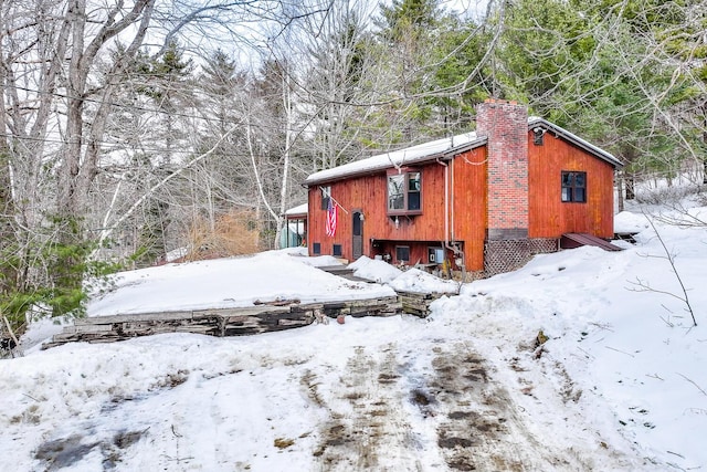 view of snow covered exterior featuring a chimney