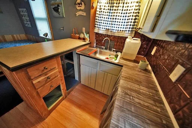 kitchen featuring sink, kitchen peninsula, and wood-type flooring