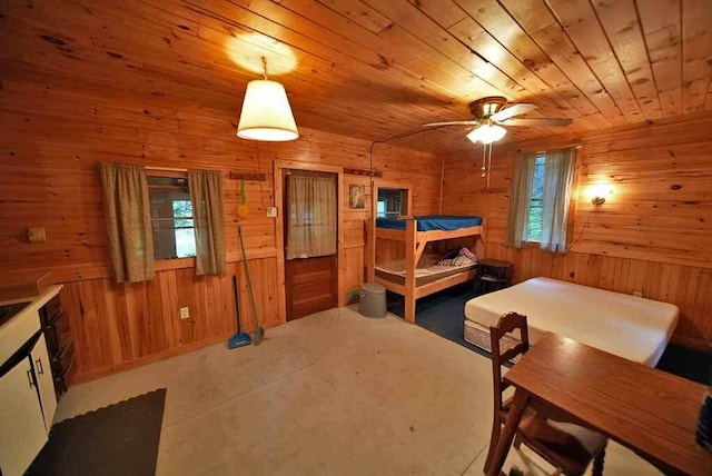 interior space with multiple windows, wood ceiling, and wooden walls