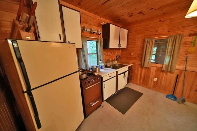 kitchen featuring wooden walls, white refrigerator, and wood ceiling