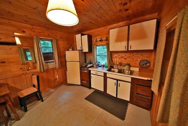 kitchen featuring wood walls, wooden ceiling, white refrigerator, and sink