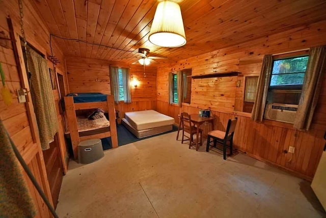 interior space featuring wood walls, ceiling fan, and wooden ceiling