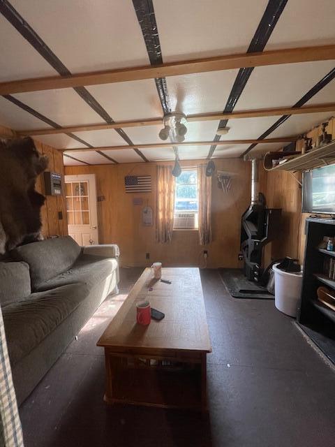 living room with wood walls and a wall unit AC