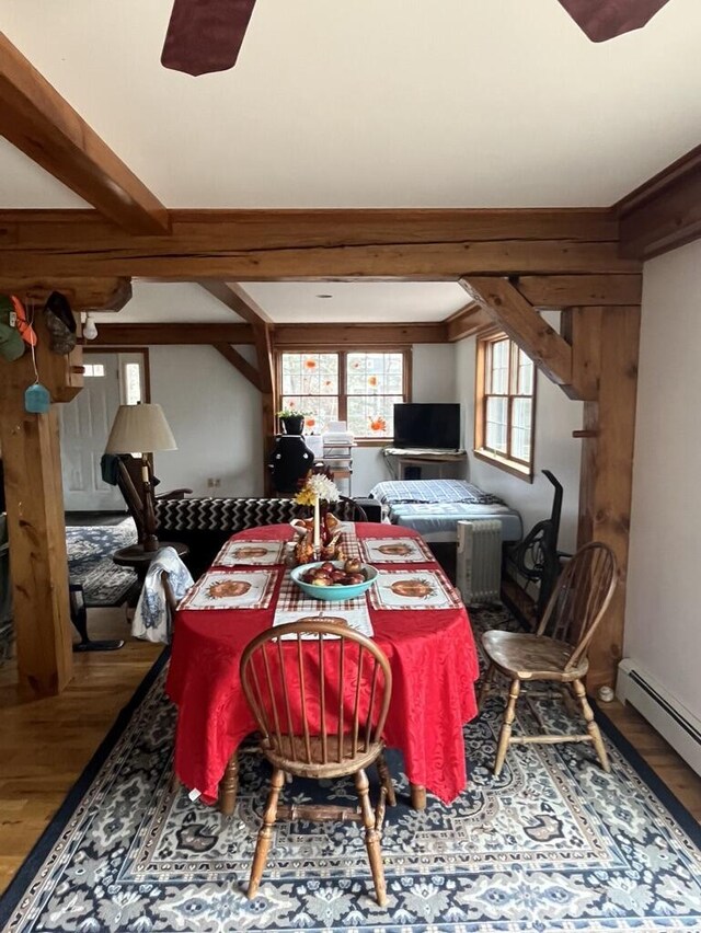 dining area featuring a ceiling fan, wood finished floors, beam ceiling, and a baseboard radiator
