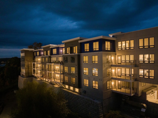 back house at twilight featuring a balcony