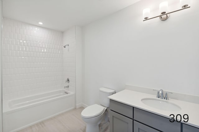 full bathroom featuring toilet, tiled shower / bath combo, and vanity