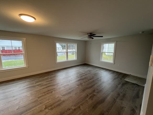 unfurnished room with ceiling fan and dark wood-type flooring