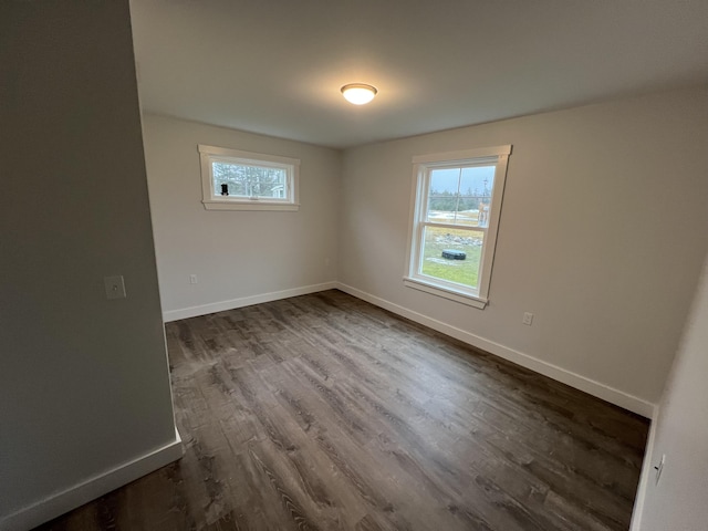 unfurnished room with dark hardwood / wood-style flooring