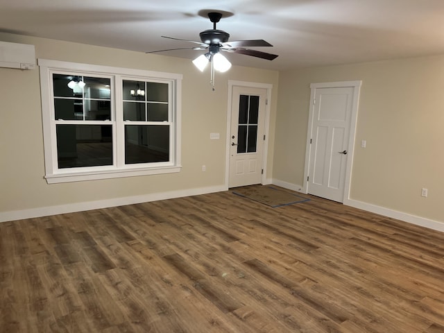 spare room with hardwood / wood-style floors, ceiling fan, and a wall mounted AC