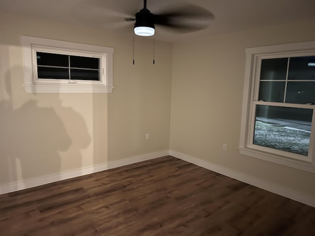 empty room with ceiling fan and dark wood-type flooring