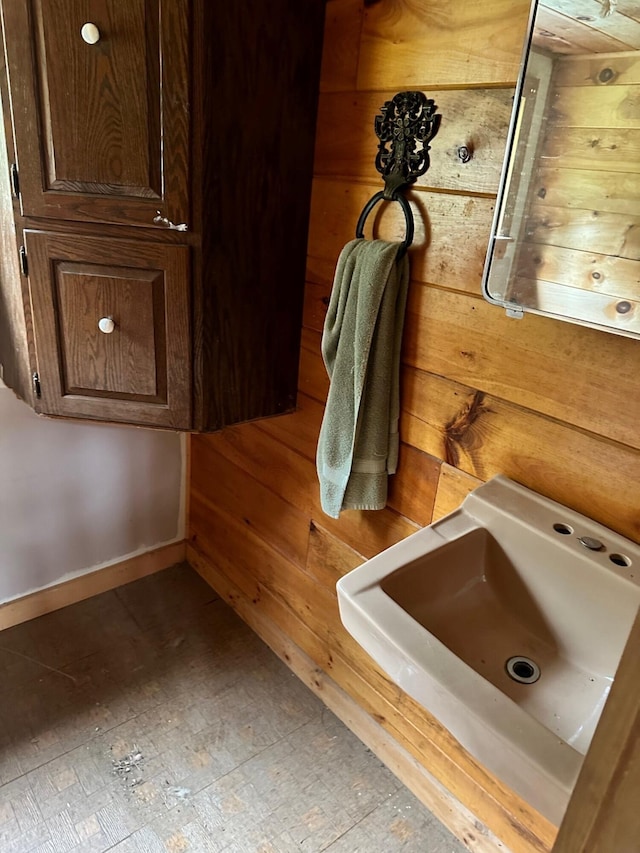 bathroom featuring sink and wooden walls