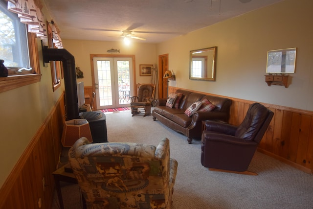 carpeted living room with french doors and ceiling fan