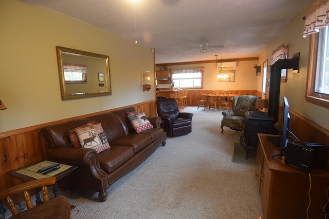 living room with ceiling fan, a wall mounted AC, and light carpet