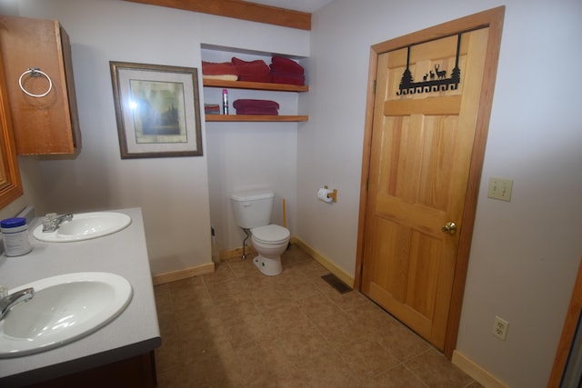 bathroom featuring toilet, double vanity, and tile flooring