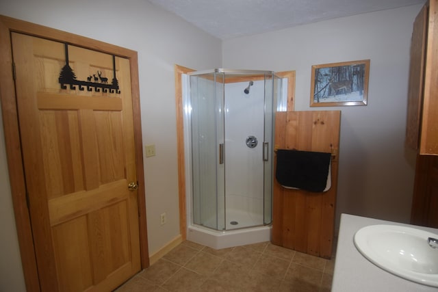 bathroom with walk in shower, sink, and tile floors