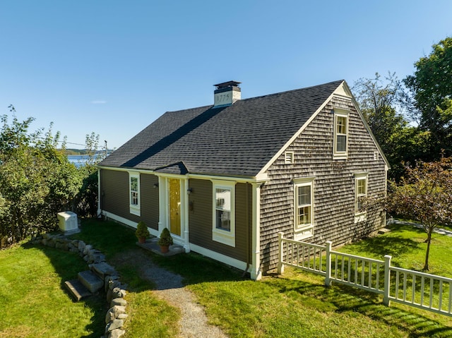 view of front facade featuring a front yard and central air condition unit