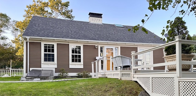 back of house featuring a yard and a wooden deck