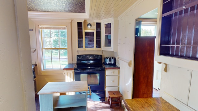 kitchen featuring white cabinetry, crown molding, and black electric range