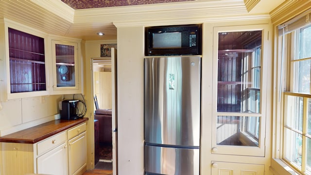 kitchen with ornamental molding and stainless steel refrigerator