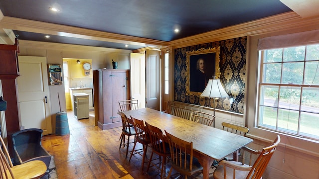 dining room with wood-type flooring, plenty of natural light, and crown molding