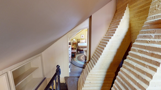 stairs featuring wood-type flooring and lofted ceiling