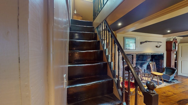 stairs featuring wood-type flooring and ornamental molding