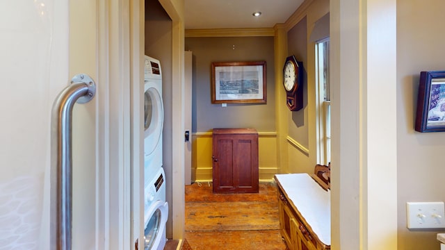 laundry room with stacked washer / dryer, hardwood / wood-style floors, and ornamental molding