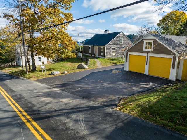 view of front of property with an outbuilding, a garage, and a front lawn