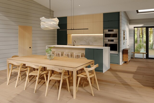 dining area with sink, light hardwood / wood-style flooring, wood walls, and vaulted ceiling