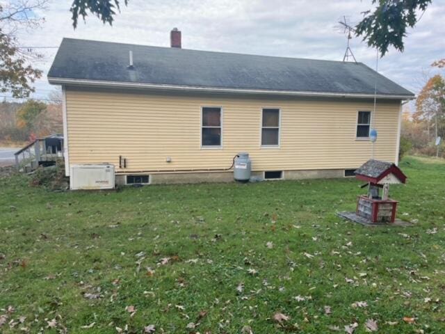 rear view of property featuring a yard