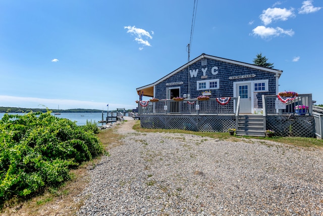 rear view of property featuring a deck with water view