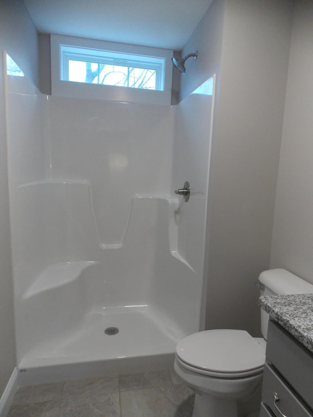 bathroom featuring a shower, tile floors, toilet, and vanity