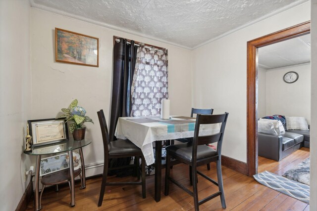 dining area featuring light wood-type flooring and a textured ceiling