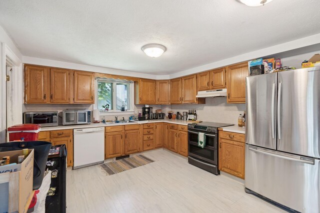 kitchen featuring appliances with stainless steel finishes, sink, and a textured ceiling