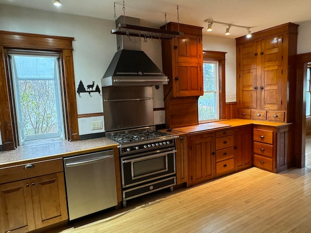 kitchen with dishwasher, double oven range, light hardwood / wood-style flooring, and a wealth of natural light