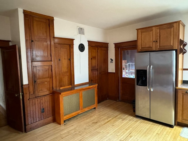 kitchen with light hardwood / wood-style flooring and stainless steel refrigerator with ice dispenser