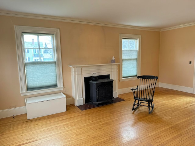 living room with light hardwood / wood-style flooring, crown molding, and a wood stove