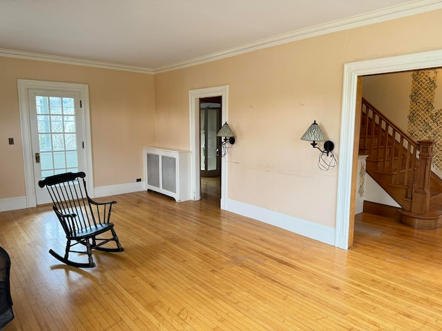 sitting room with crown molding, radiator, and light hardwood / wood-style flooring