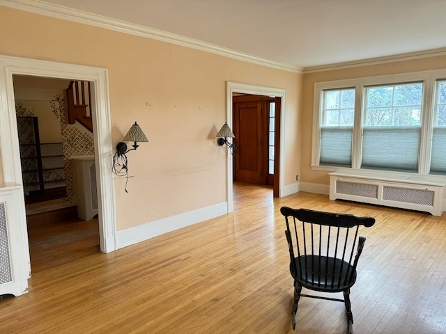 interior space with crown molding, radiator, and light hardwood / wood-style flooring