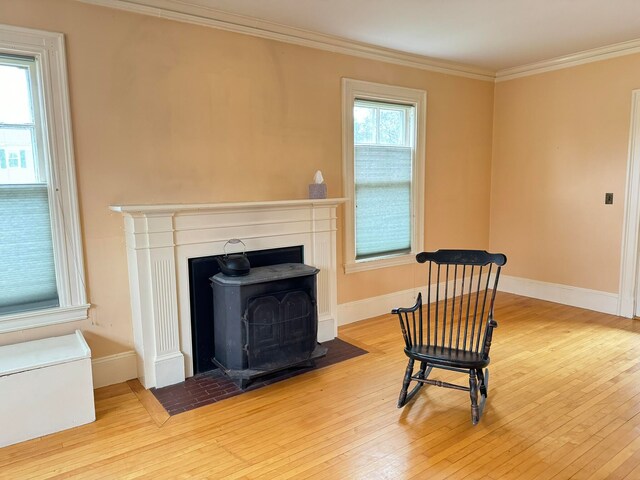 sitting room with ornamental molding and light hardwood / wood-style flooring