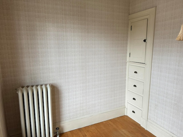 interior space with radiator heating unit and light hardwood / wood-style floors