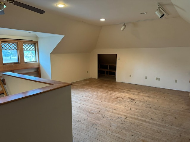 additional living space with ceiling fan, vaulted ceiling, and light hardwood / wood-style flooring